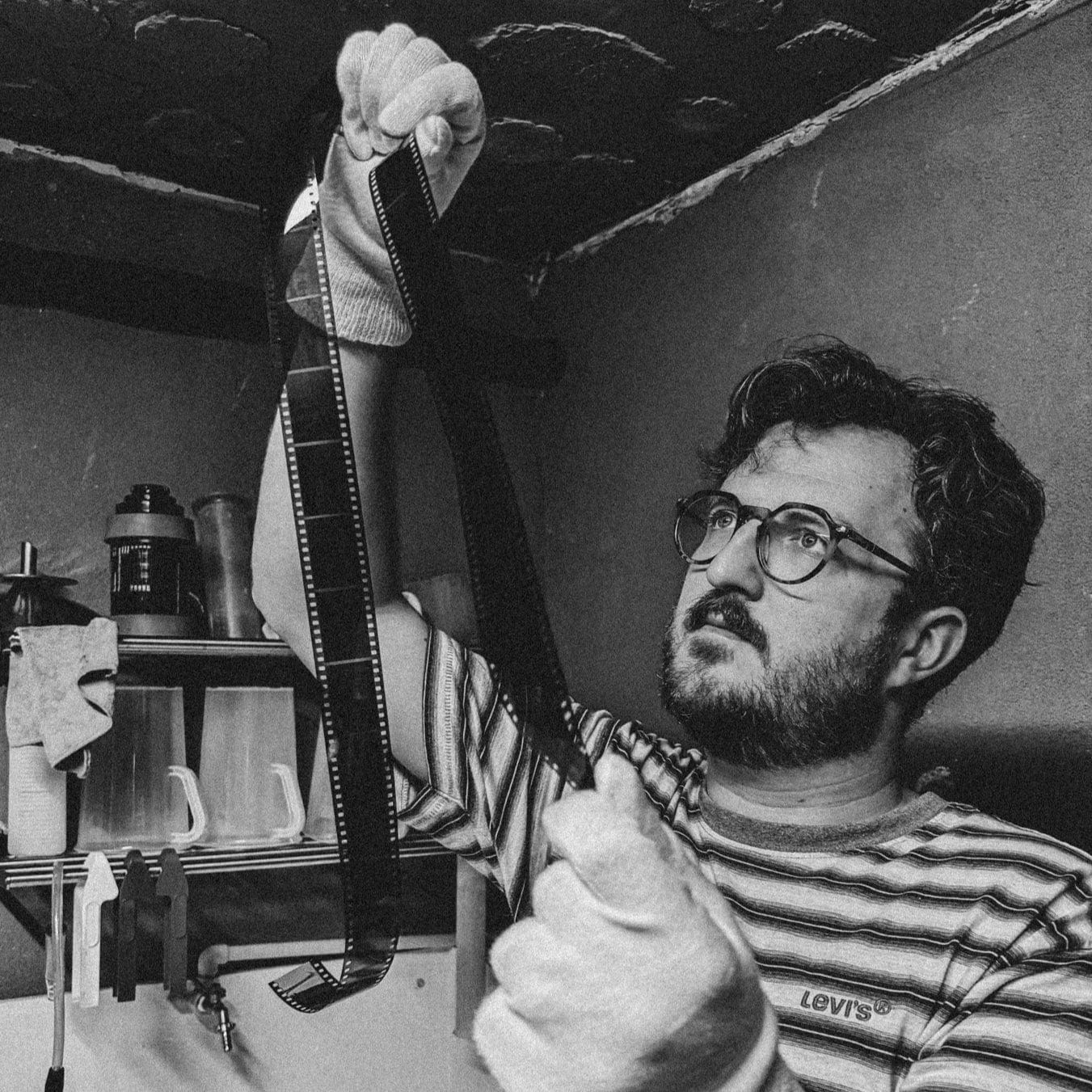 Person holding a large roll of film in a darkroom setting