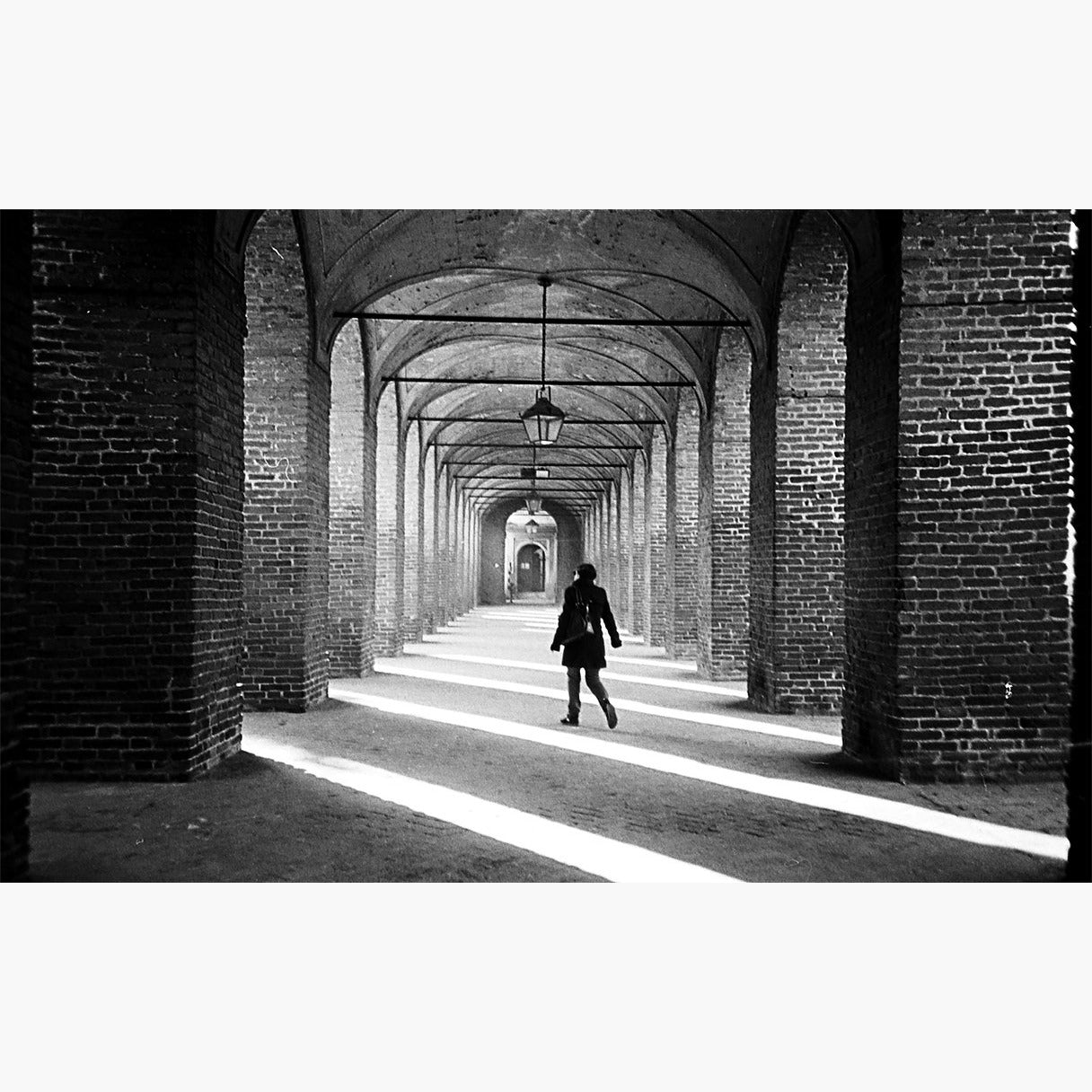 woman talking through arches - Ilford HP5 Plus 400 ISO 35mm black and white film example image